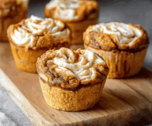 Delicious pumpkin cheesecake muffins with creamy cream cheese filling and a golden-brown top, perfect for fall dessert or breakfast.