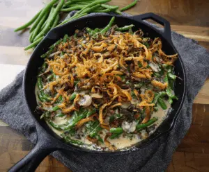 Delicious skillet green bean casserole topped with crispy fried onions, ready to serve as a savory side dish.