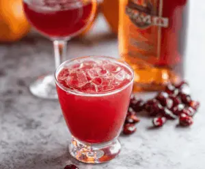 Amaretto Cranberry Kiss Cocktail in a elegant glass with fresh cranberries and a lemon garnish