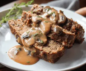 Delicious homemade meatloaf topped with rich mushroom gravy served on a plate