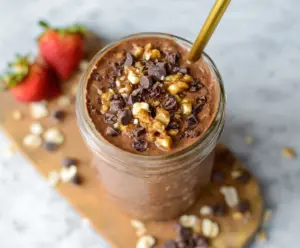 Creamy brownie batter overnight oats in a glass jar with chocolate topping