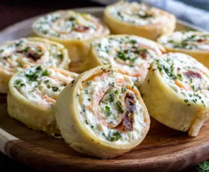 Delicious cream cheese pinwheels filled with savory ingredients on a wooden platter.