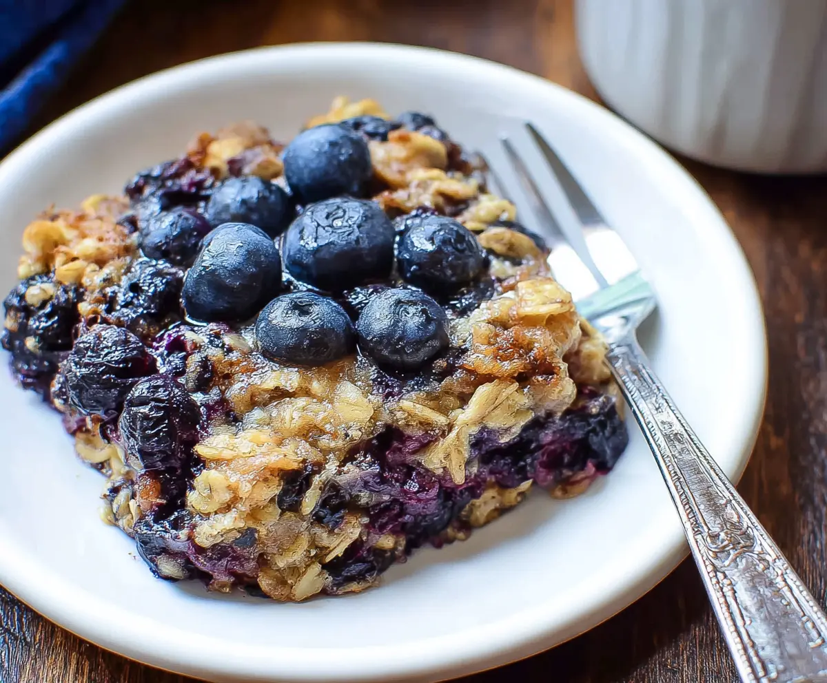 Delicious baked blueberry oatmeal served in a bowl, showcasing fresh blueberries and golden oats.