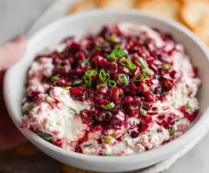 Creamy cranberry jalapeno cream cheese dip served with fresh vegetables and crackers.