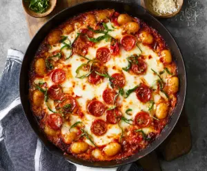 Delicious Gnocchi Pizza topped with melted cheese and fresh herbs, ready to serve.