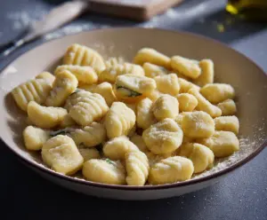 Delicious homemade potato gnocchi served with fresh herbs and Parmesan cheese.