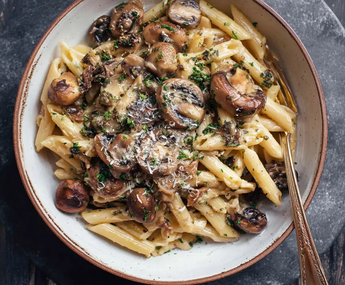 Delicious mushroom pasta with creamy sauce served on a plate.