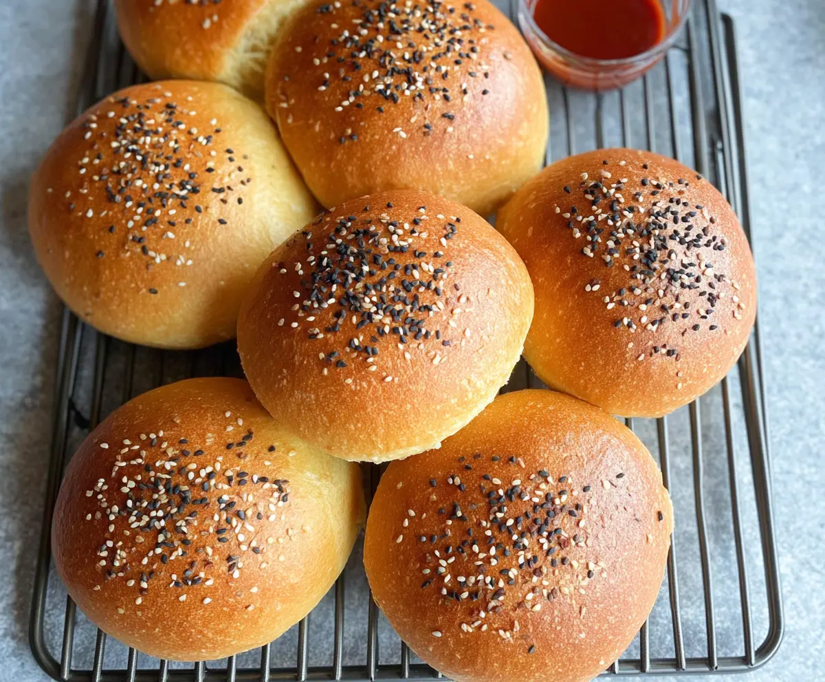 Homemade sourdough discard hamburger buns on a wooden surface