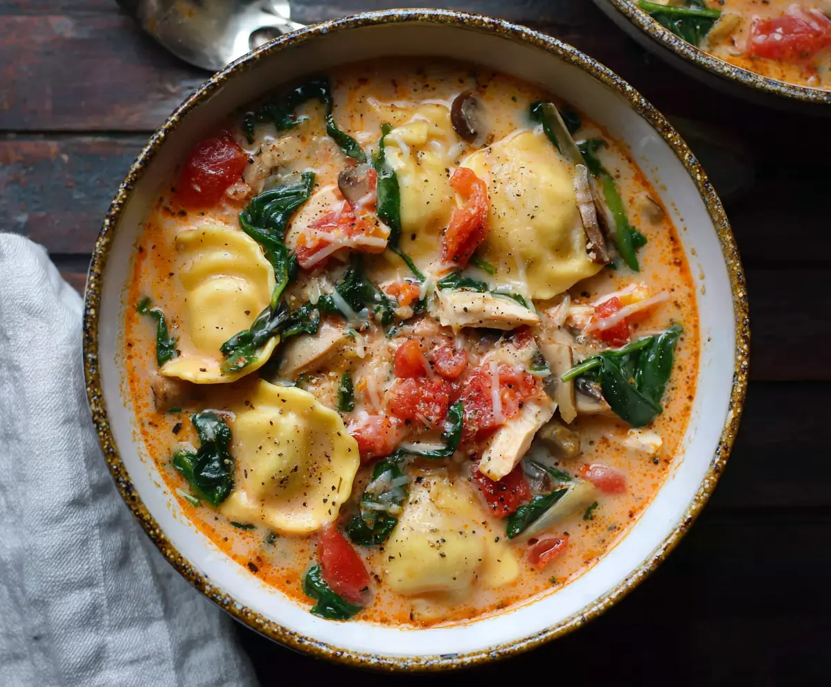 Delicious Tuscany-inspired Ravioli Soup with fresh herbs and vegetables in a savory broth.
