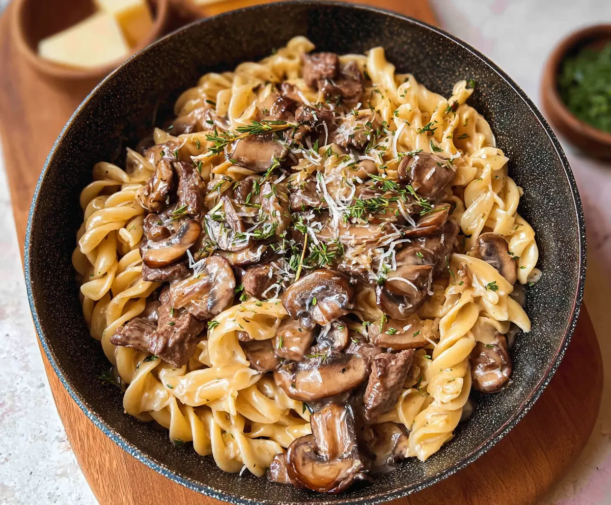 Delicious beef stroganoff served over creamy pasta with mushrooms and herbs.