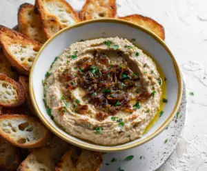 Creamy Caramelized Onion White Bean Dip garnished with fresh herbs, perfect for snacks and appetizers.