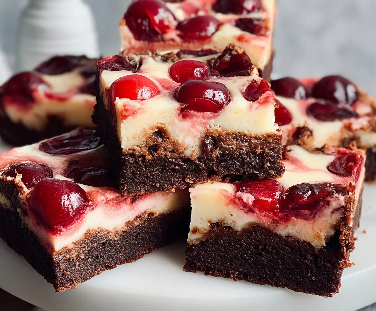 Delicious cherry cheesecake brownies with a rich chocolate crust and creamy cherry filling topped with fresh cherries