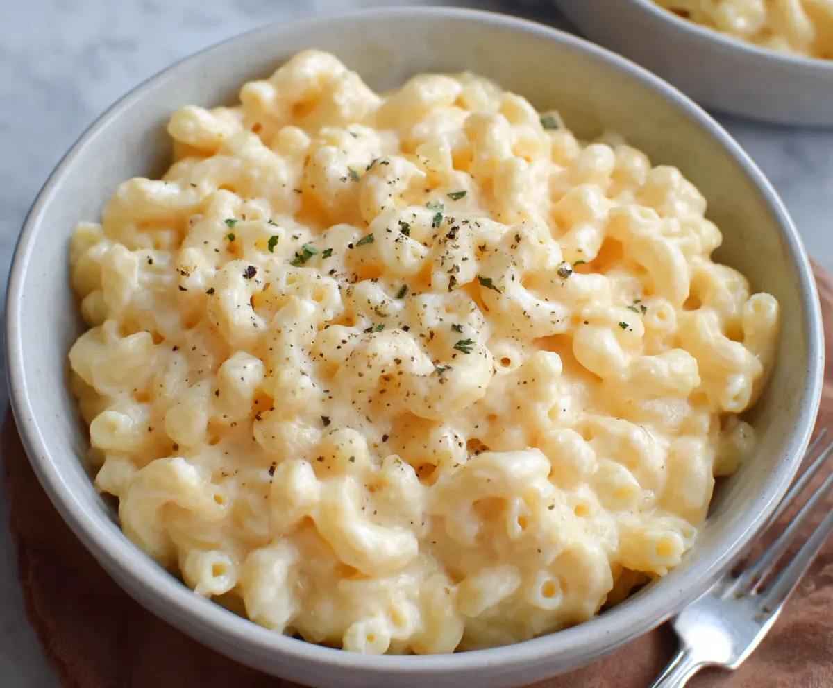 Creamy cottage cheese mac and cheese served in a bowl, garnished with herbs for a nutritious twist.