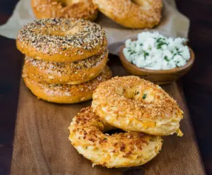 Delicious creamy cheddar bagels on a white plate, perfect for breakfast or snack.