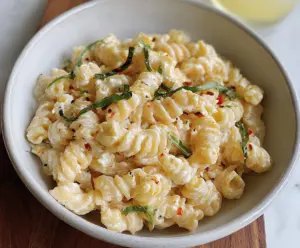 Delicious creamy cottage cheese pasta served on a plate, garnished with herbs.
