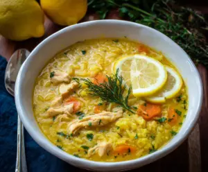 Homemade Lemon Ginger Turmeric Chicken and Rice Soup with fresh herbs and vibrant ingredients.