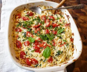 Creamy Boursin Orzo Bake in a baking dish, garnished with fresh herbs for a delicious main course.