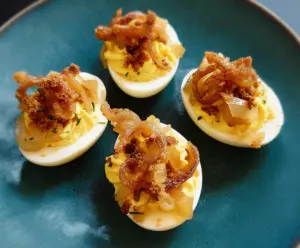 Creamy French Onion Deviled Eggs garnished with caramelized onions and fresh herbs.